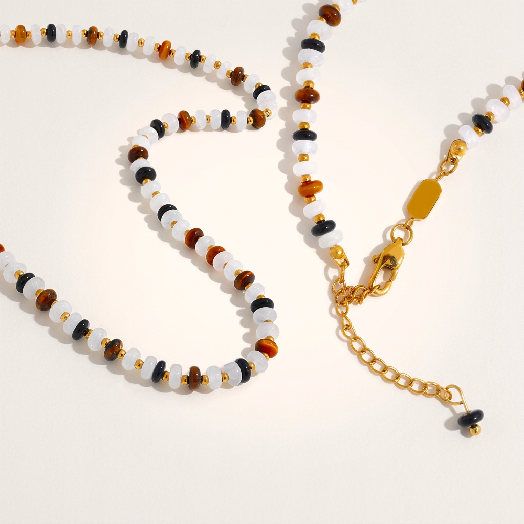 Close-up of agate and tiger eye necklace styled for prosperity and abundance, with soft lighting and detailed focus on gemstones.