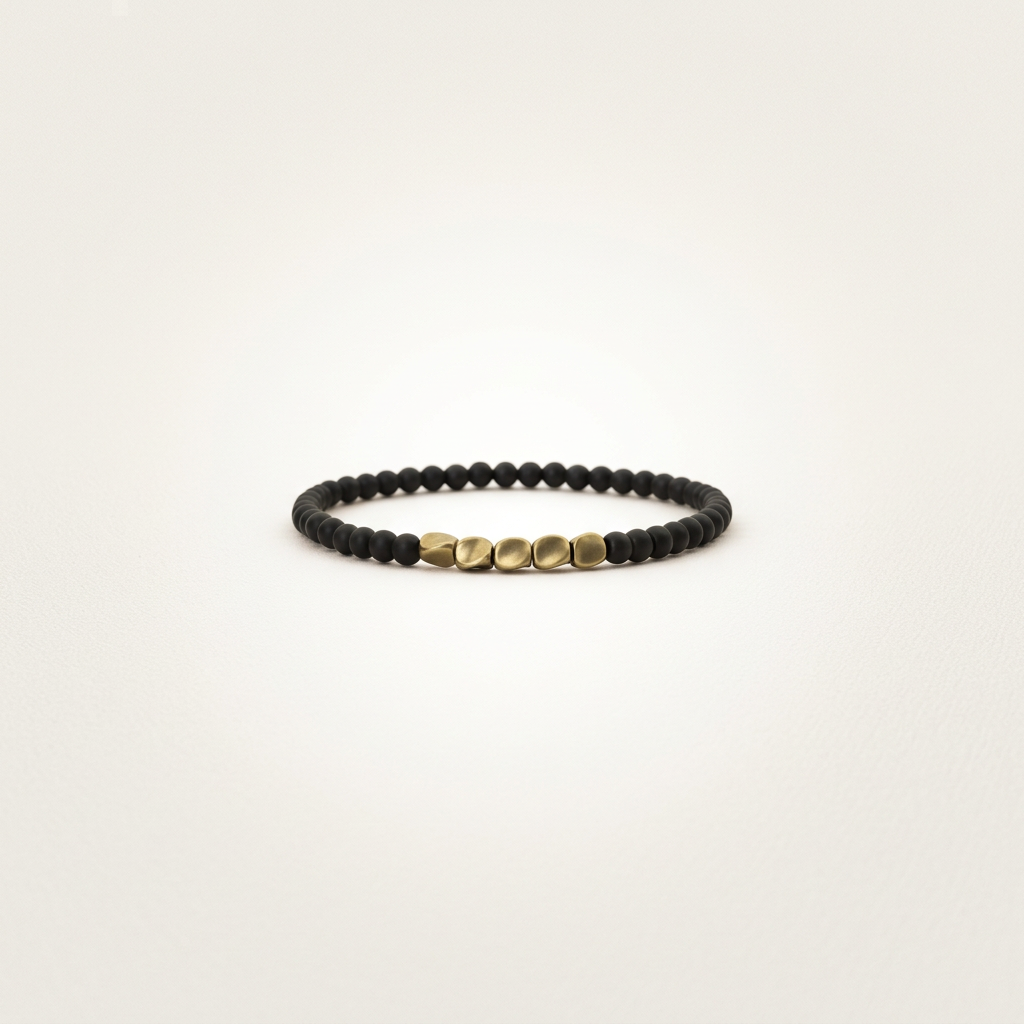 Close-up of black agate and copper jewelry for stress relief, on a matte warm bone background with soft, high-key lighting.