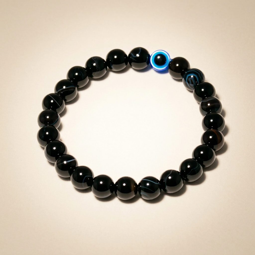 Close-up of a black tourmaline evil eye bracelet on a warm matte background, showcasing protective and purifying properties in a detailed jewelry shot.
